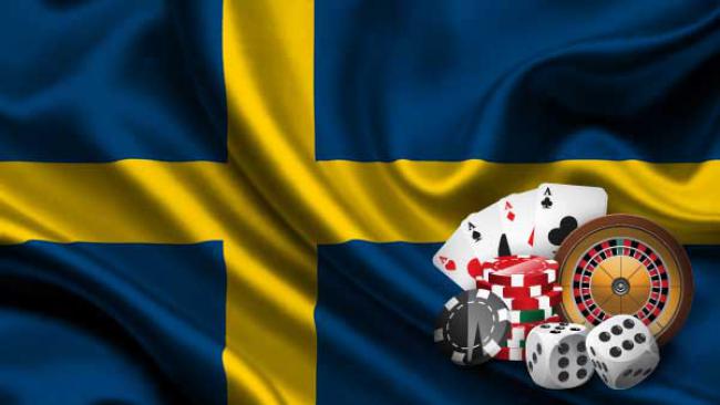 Svensk flagga med spelkort, rouletthjul, tärningar och spelmarker framför
